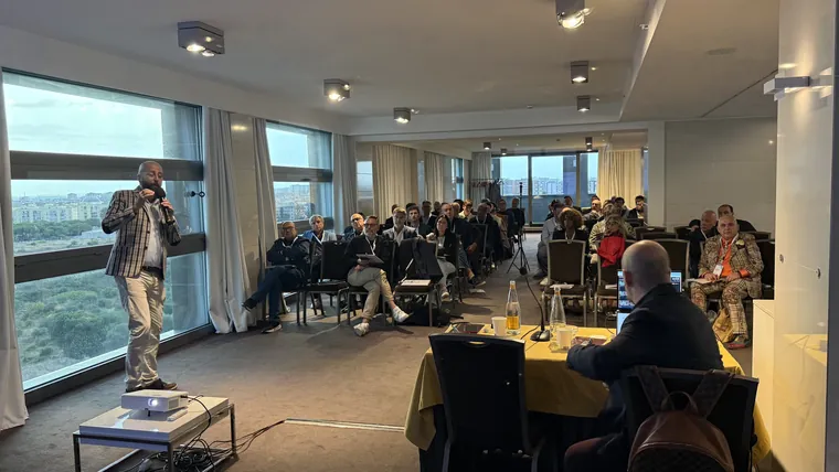 La sala dell'Hotel Parco dei Principi vista dal fondo, con il pubblico seduto e il relatore in piedi